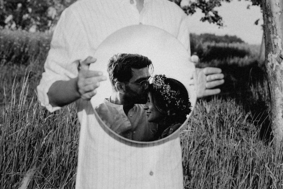 Kreative Fotografie mit Spiegel in dem sich ein Paar küsst