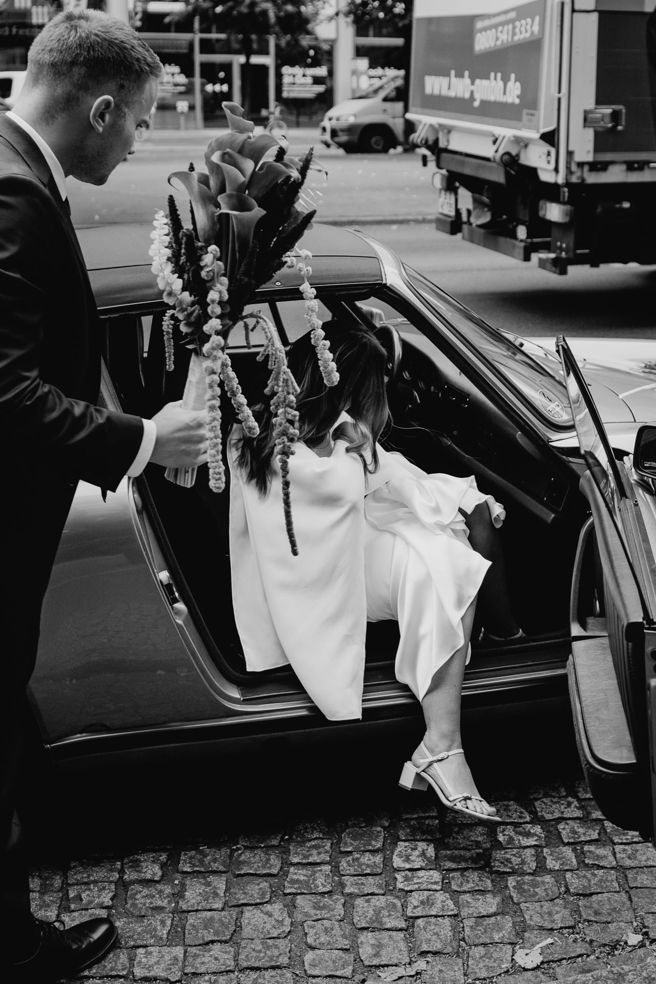 Auf dem Weg zur Trauung: Braut steigt ins Hochzeitsauto ein. Fotografiert von Laura-Sophie Jung, Berlin.