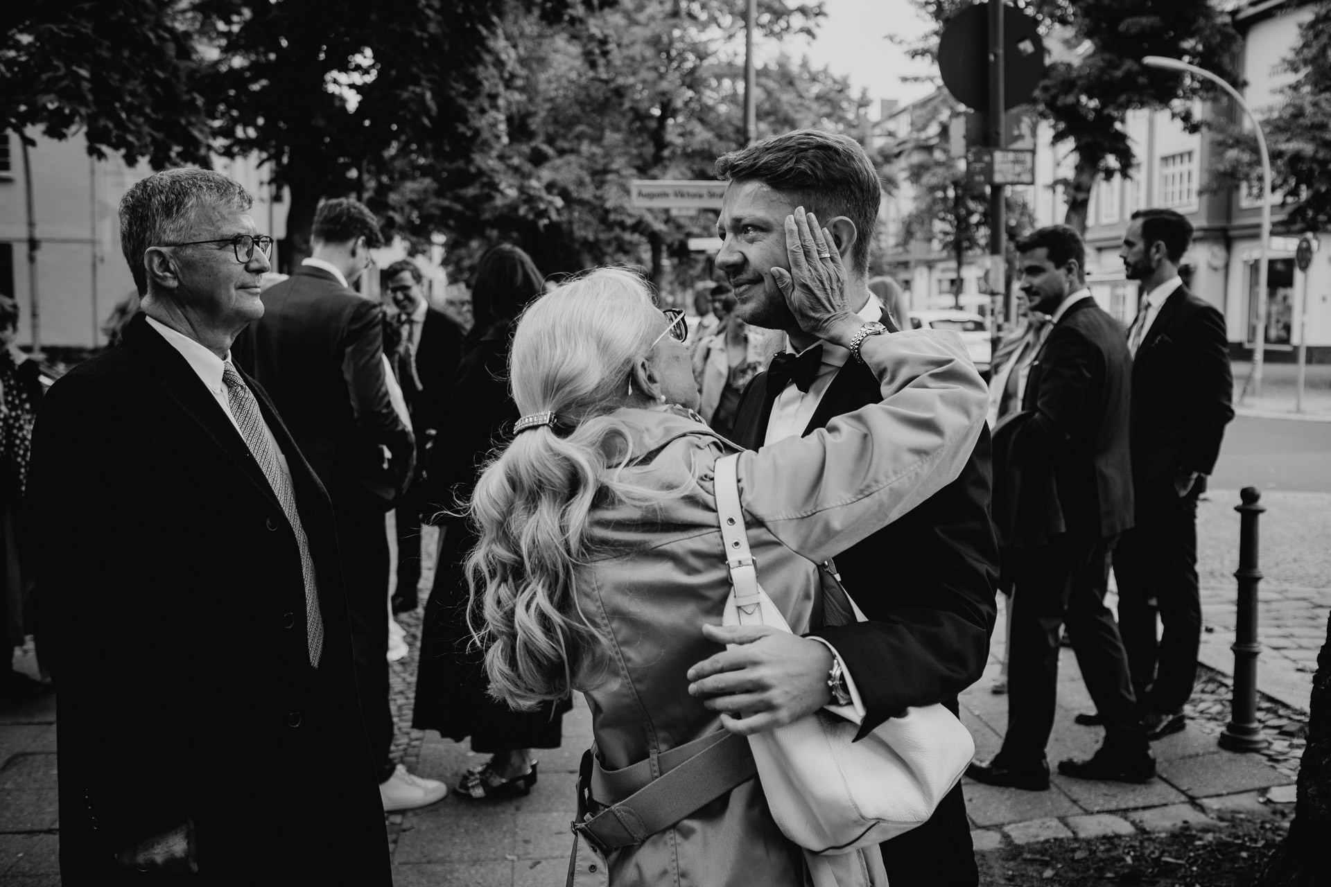 Große Emotionen am Hochzeitstag: Bräutigam vor dem Standesamt im Kreis der Familie mit Tränen in den Augen. Emotionales Hochzeitsfoto in schwarz-weiß von Laura-Sophie Jung.