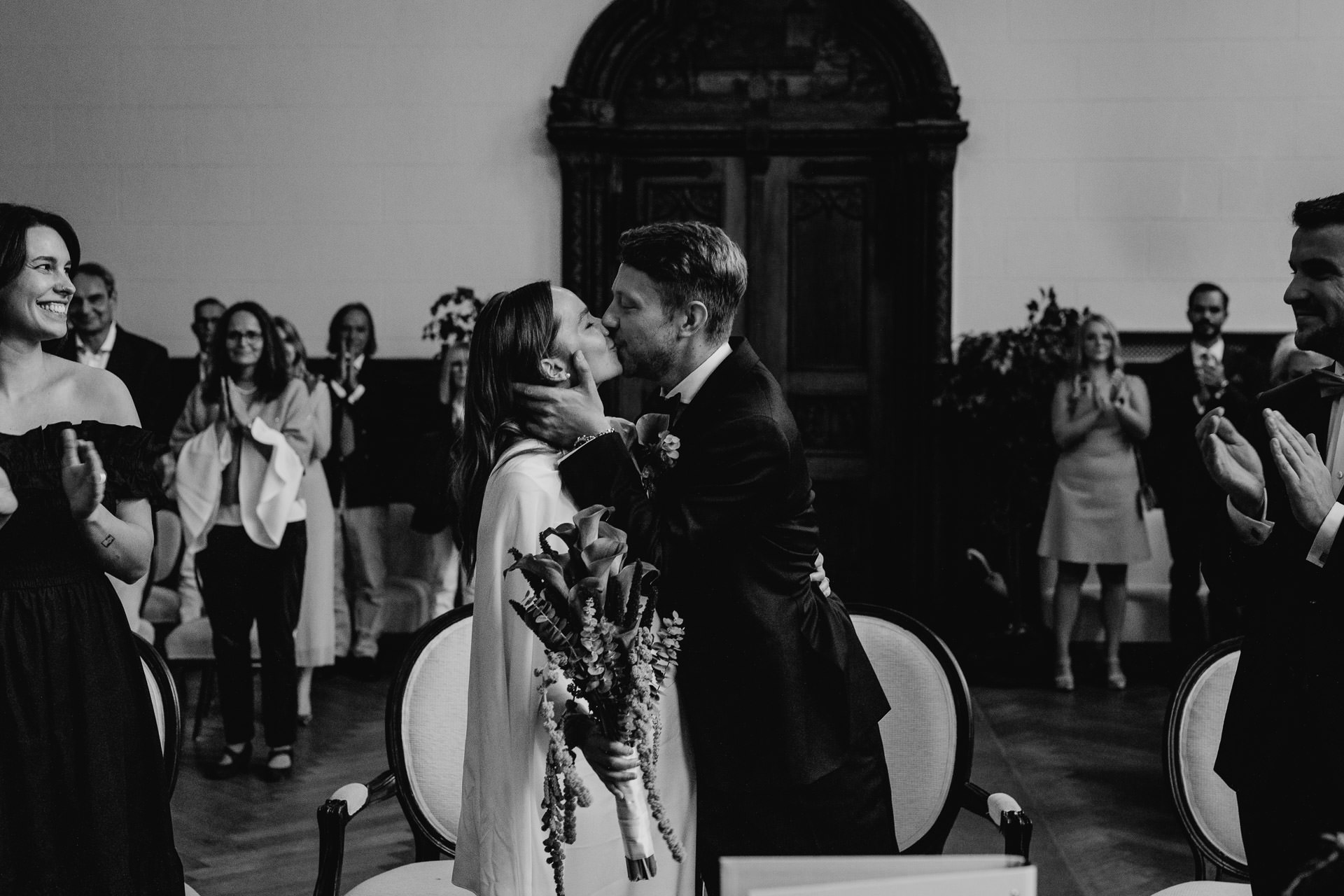 Emotionale Hochzeitsfotos: Braut und Bräutigam küssen sich bei der standesamtlichen Trauung. Schwarz-weiß Bild von Hochzeitsfotografin Laura-Sophie Jung.