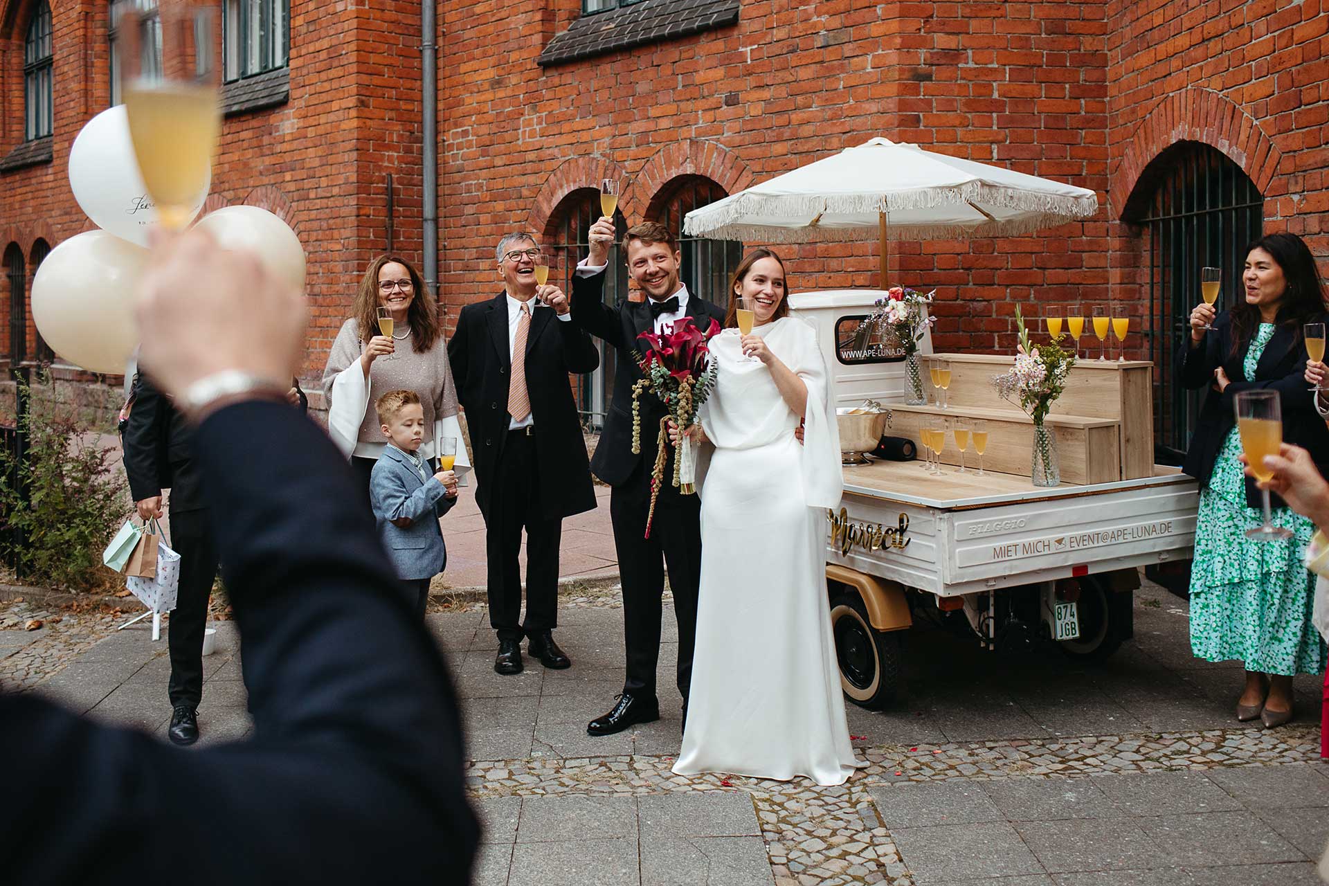 Nach der Trauung: Glückliches Brautpaar und Gäste beim Empfang vor dem Standesamt Schmargendorf. Hochzeitsbild von Laura-Sophie Jung.