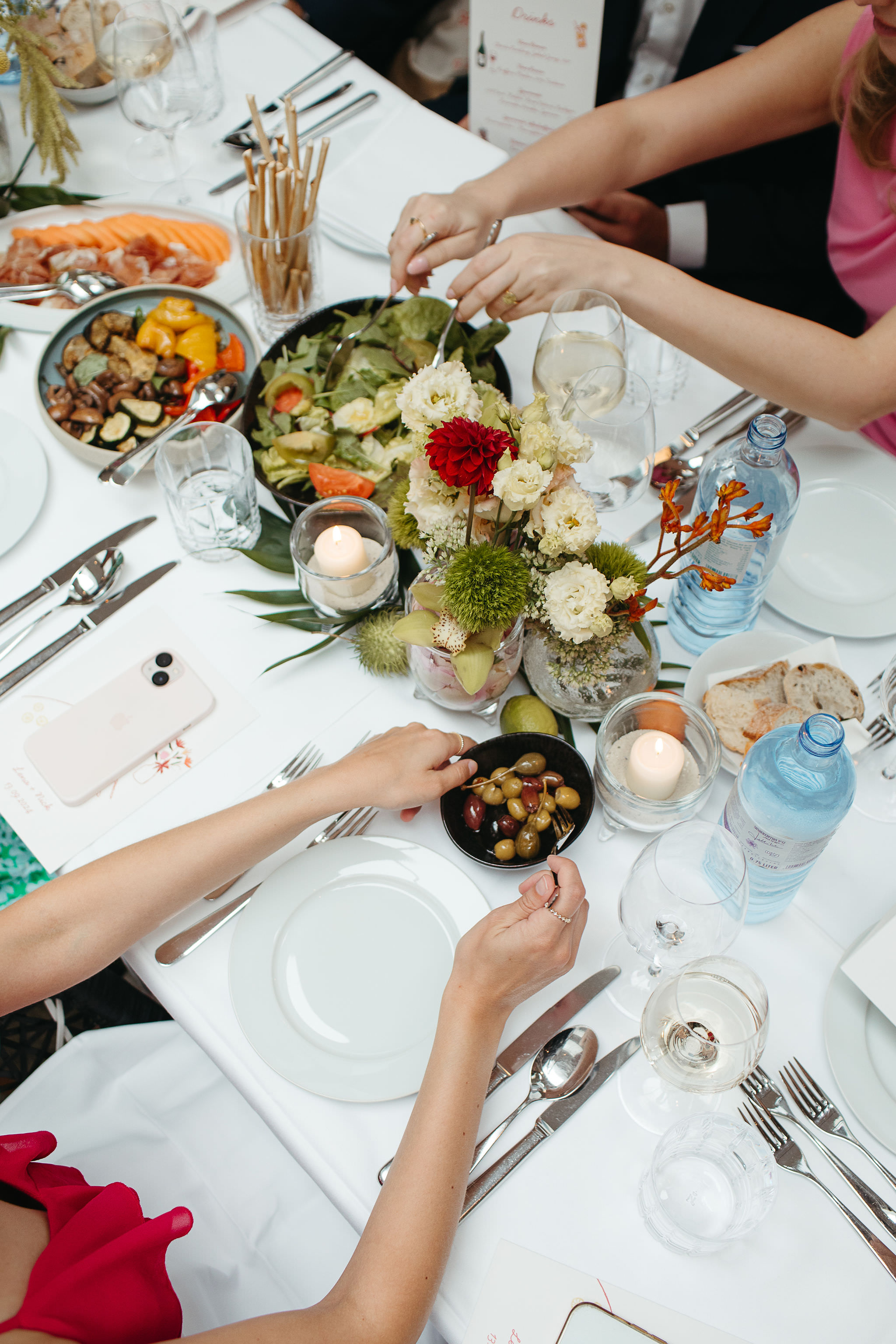 Hochzeitsessen im SO/ Berlin Das Stue: Gäste bedienen sich am gedeckten Tisch an den Vorspeisen, fotografiert von oben von Fotografin Laura-Sophie Jung.