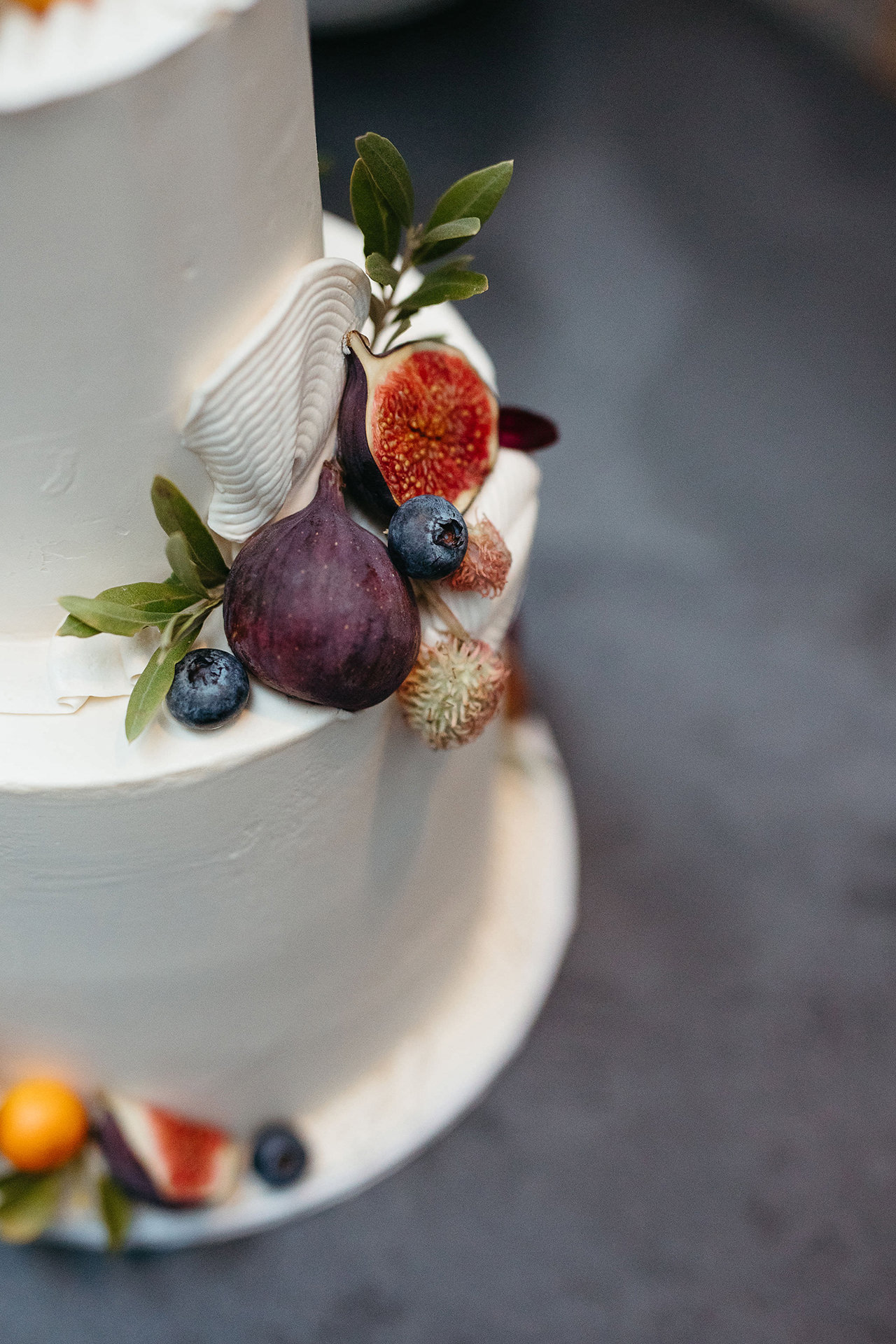 Hochzeitstorte - Detailaufnahme der Dekoration mit Beeren, Feigen und Kräutern. Bild von Hochzeitsfotografin Berlin, Laura-Sophie Jung.