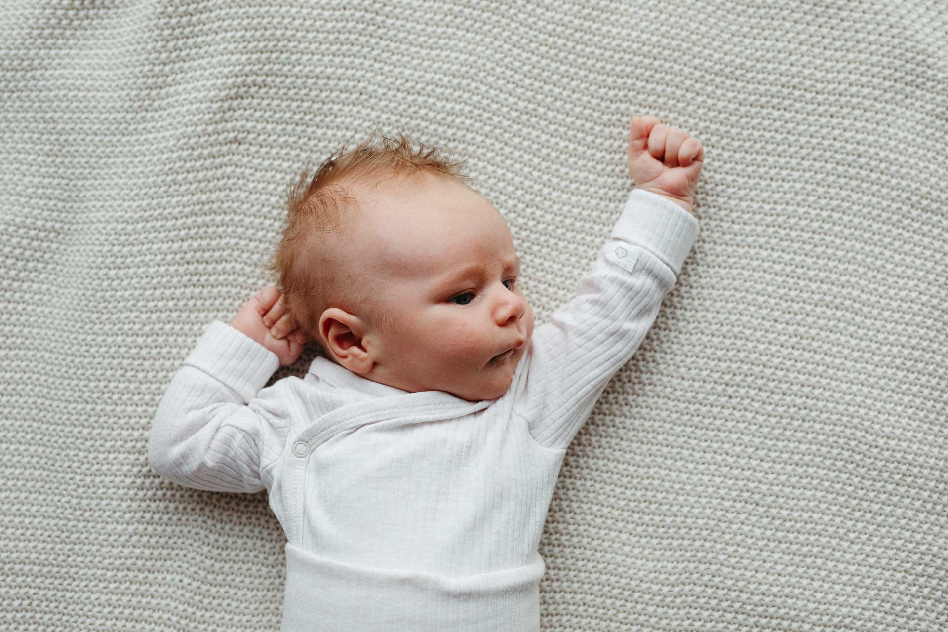 Familien Homestory: Baby liegt auf einer Decke. Fotografiert von Laura-Sophie Jung, Berlin.