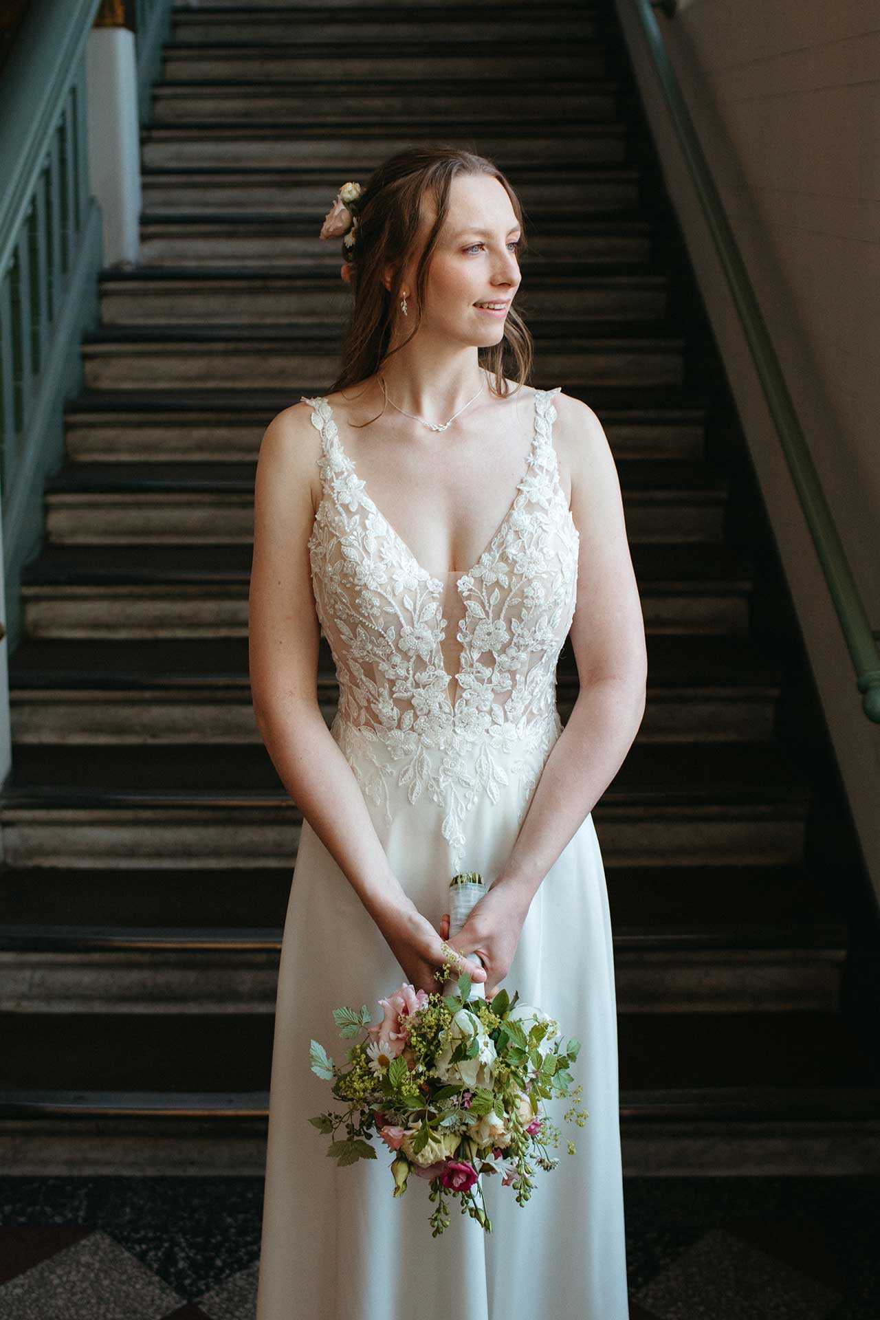 Hochzeitsfotos Standesamt: Braut lächelt glücklich und hält Brautstrauße in der Hand. Fotografiert von Laura-Sophie Jung