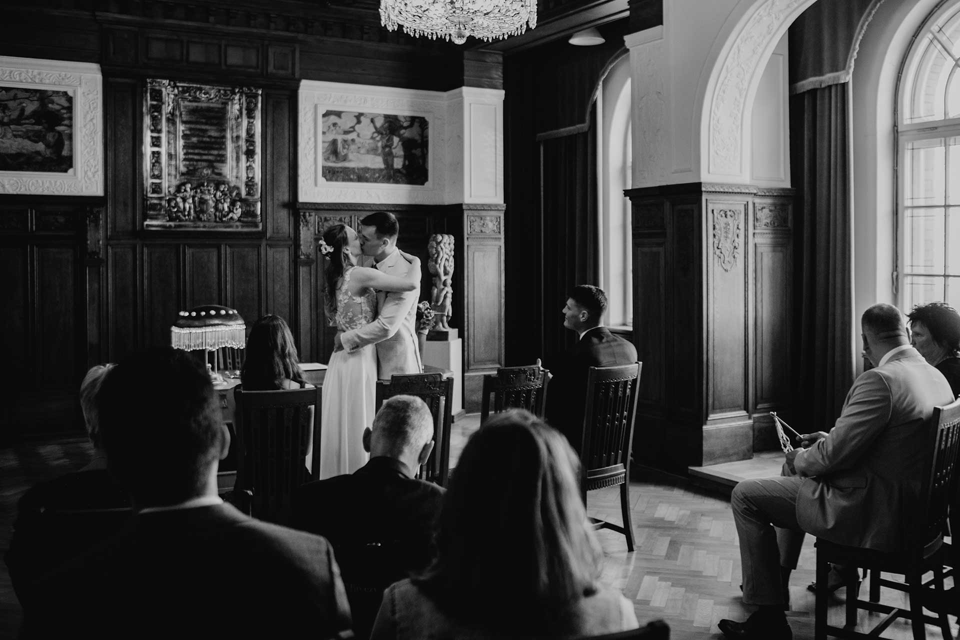 Hochzeitsfotos Standesamt: Paar küsst sich während der standesamtlichen Trauung. Fotografiert von Laura-Sophie Jung