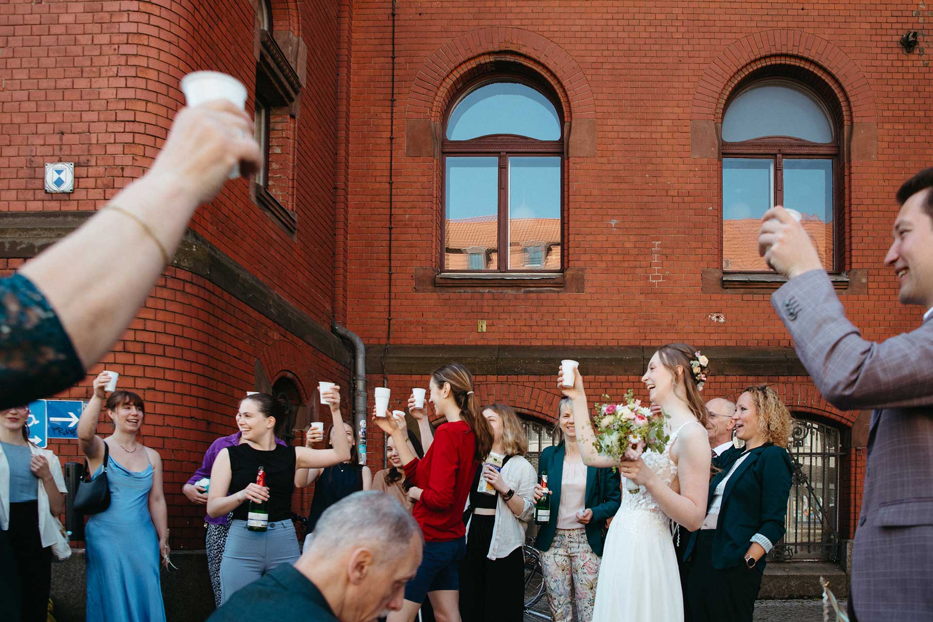 Hochzeitsfotos Standesamt: Gemeinsames Anstoßen in der Gruppe. Fotografiert von Laura-Sophie Jung