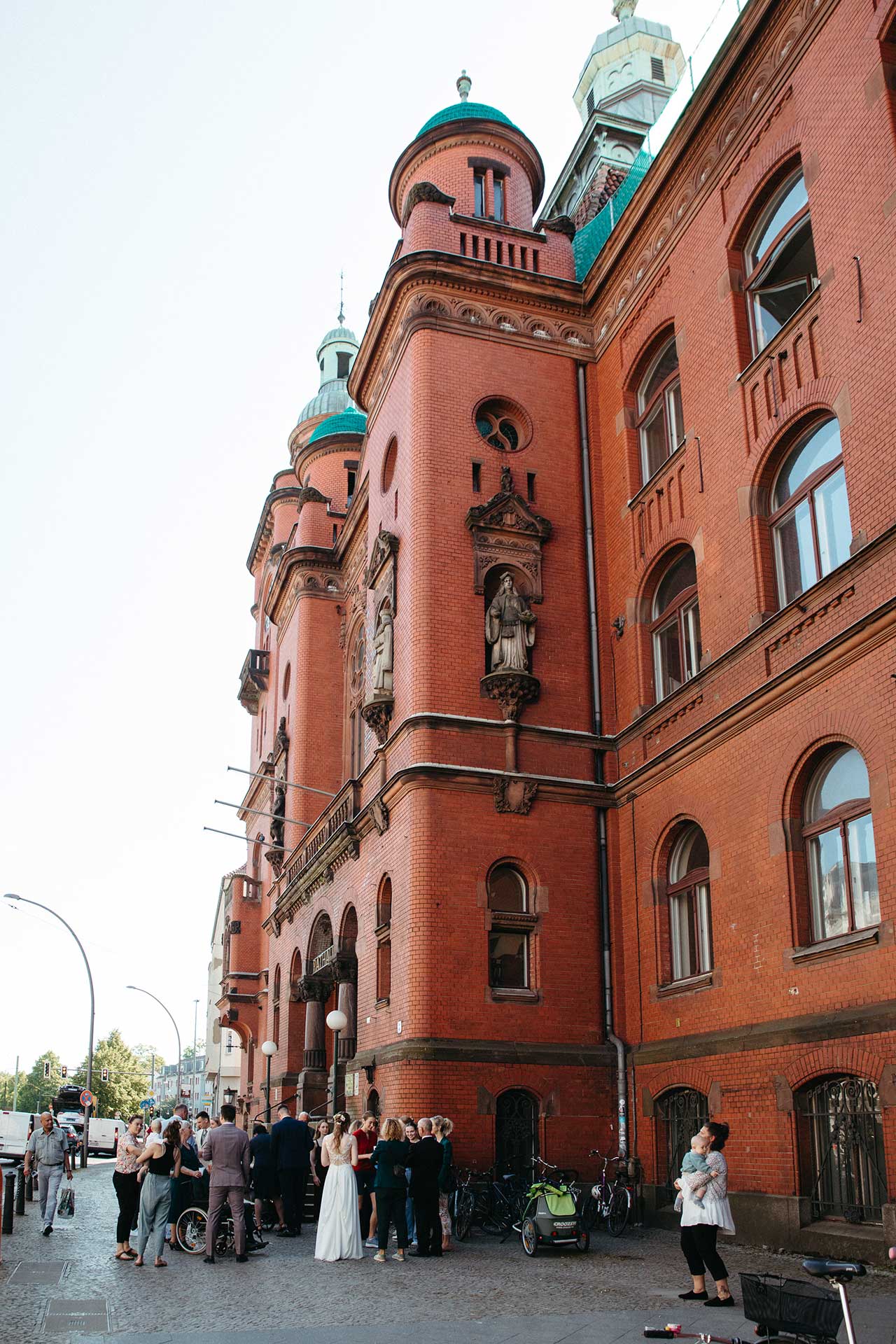 Hochzeitsfotos Standesamt: Menschengruppe steht vor Rathausgebäude. Fotografiert von Laura-Sophie Jung