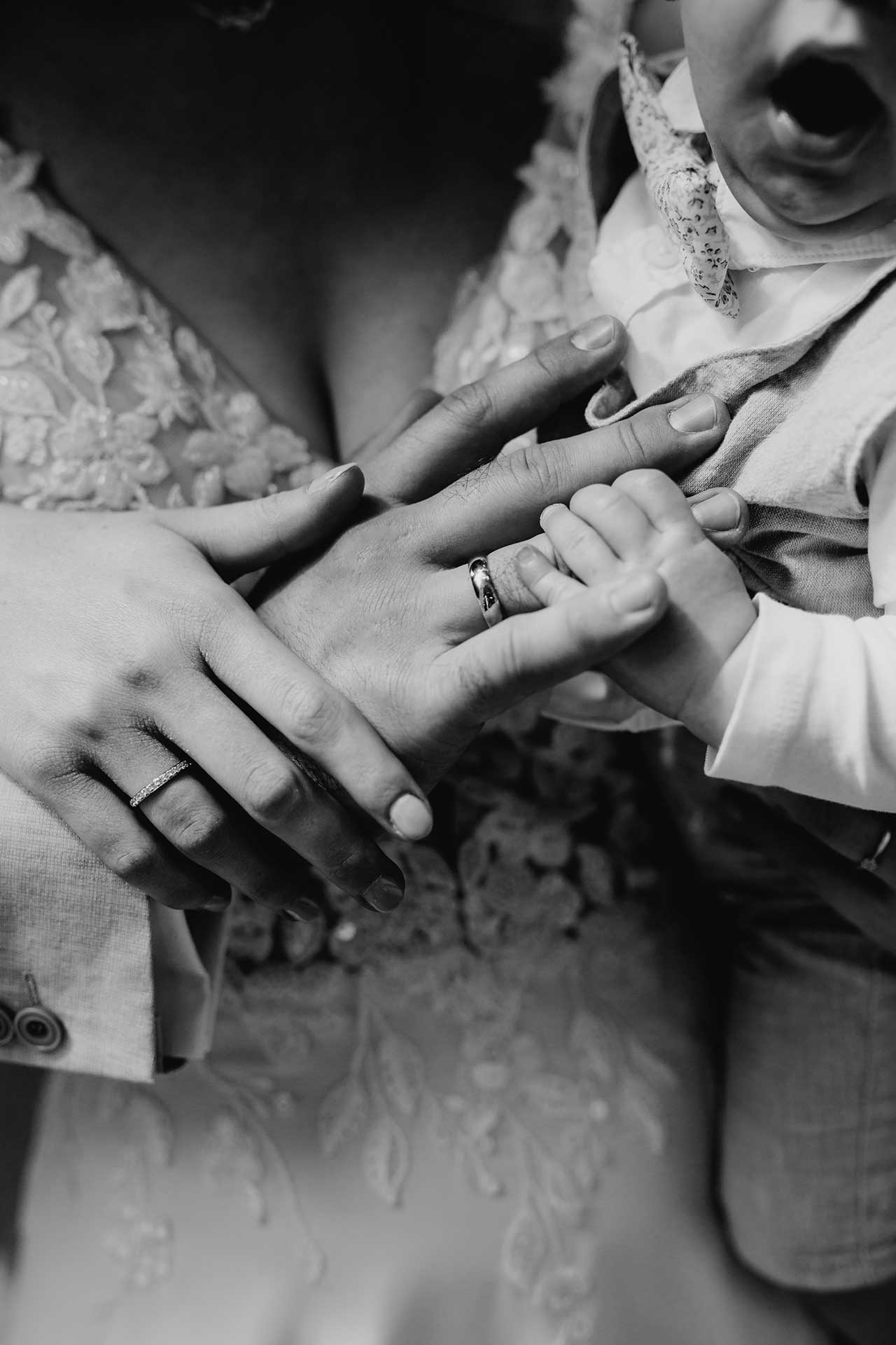 Hochzeitsfotos Standesamt: Babyhand greift Hände der Eltern. Fotografiert von Laura-Sophie Jung