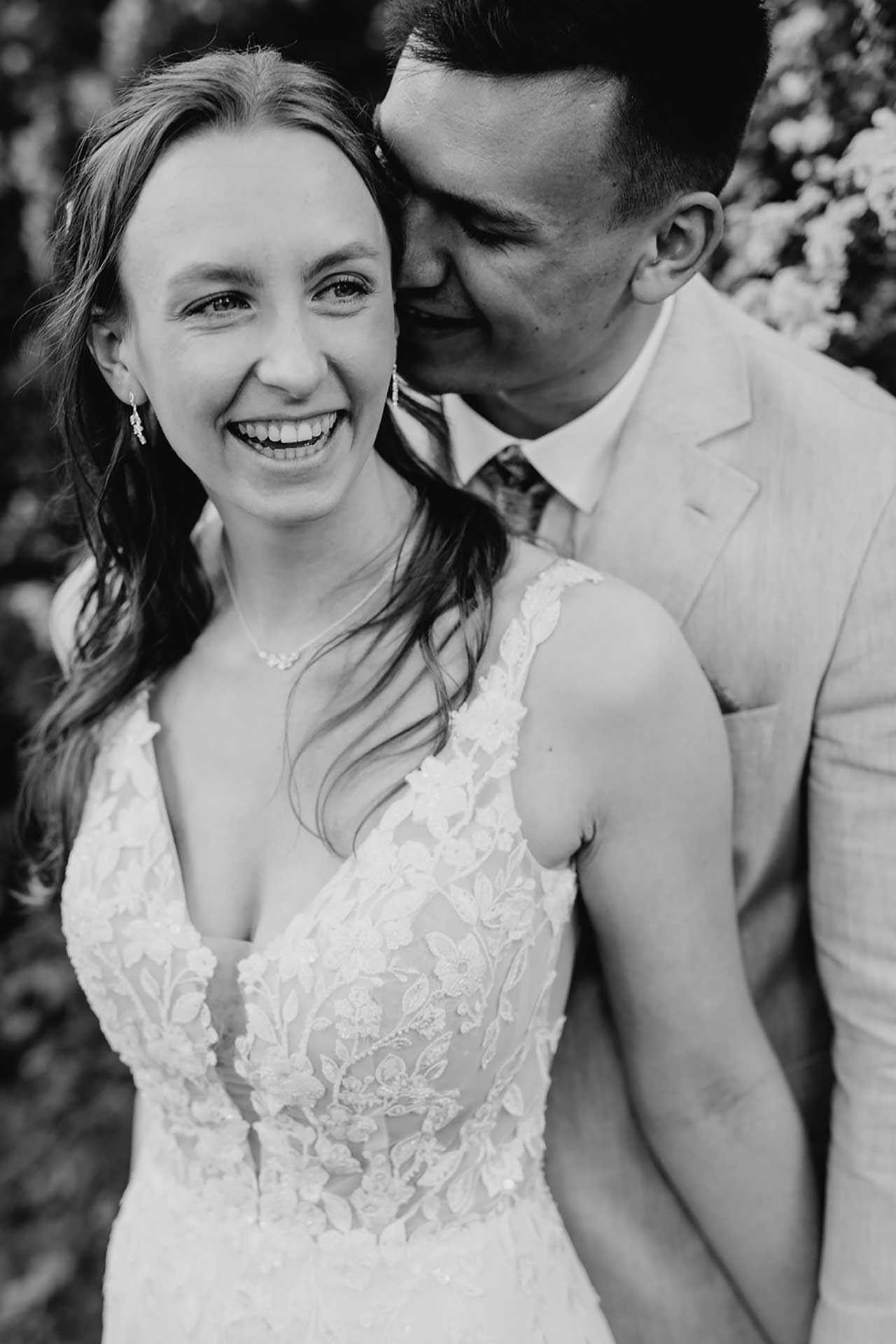 Hochzeitsfotos Standesamt: Bräutigam umarmt lachende Braut. Fotografiert von Laura-Sophie Jung