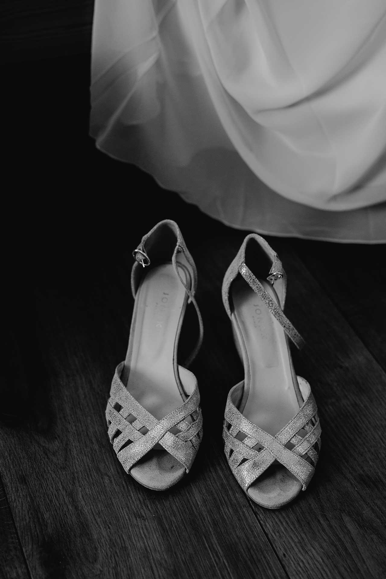 Hochzeitsbild mit Liebe zum Detail: Die Schuhe der Braut. Schwarz-weiß Bild von Laura-Sophie Jung.