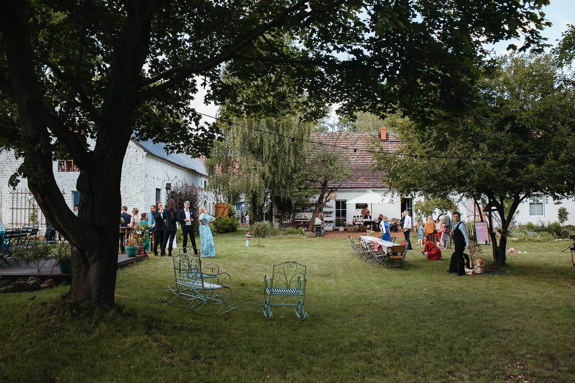 Heiraten auf dem Land in Brandenburg: Gäste bei der Hochzeitsfeier im Garten der Location. Foto von Laura-Sophie Jung.