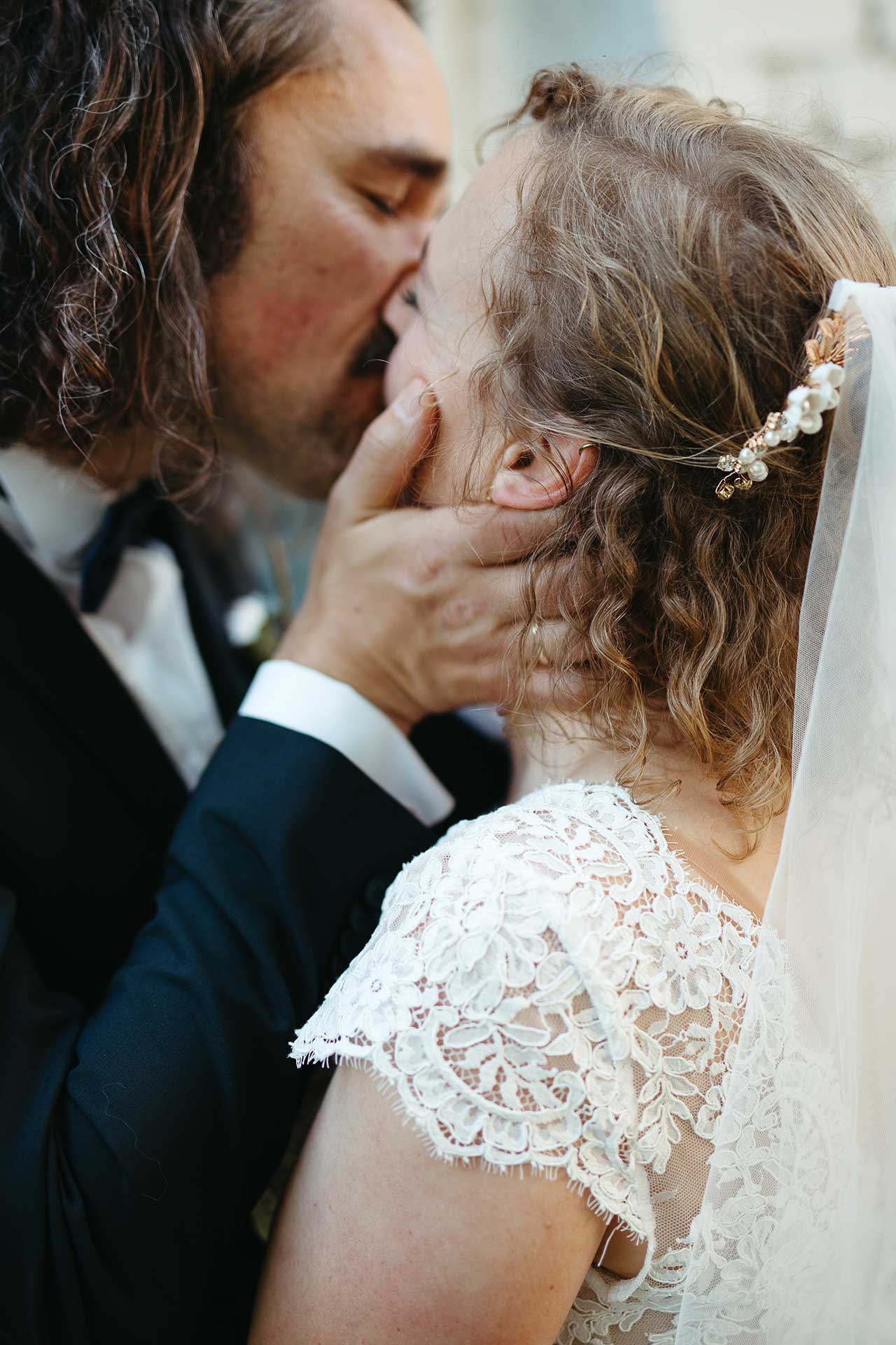 Liebevoller Moment: Braut und Bräutigam küssen sich zärtlich. Hochzeitsfoto von Laura-Sophie Jung.