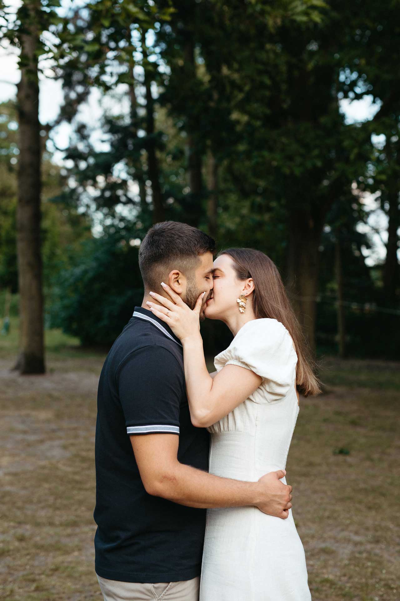 Paar beim Verlobungsshooting outdoor: Mann und Frau küssen sich zärtlich. Fotografiert von Laura-Sophie Jung, Berlin.