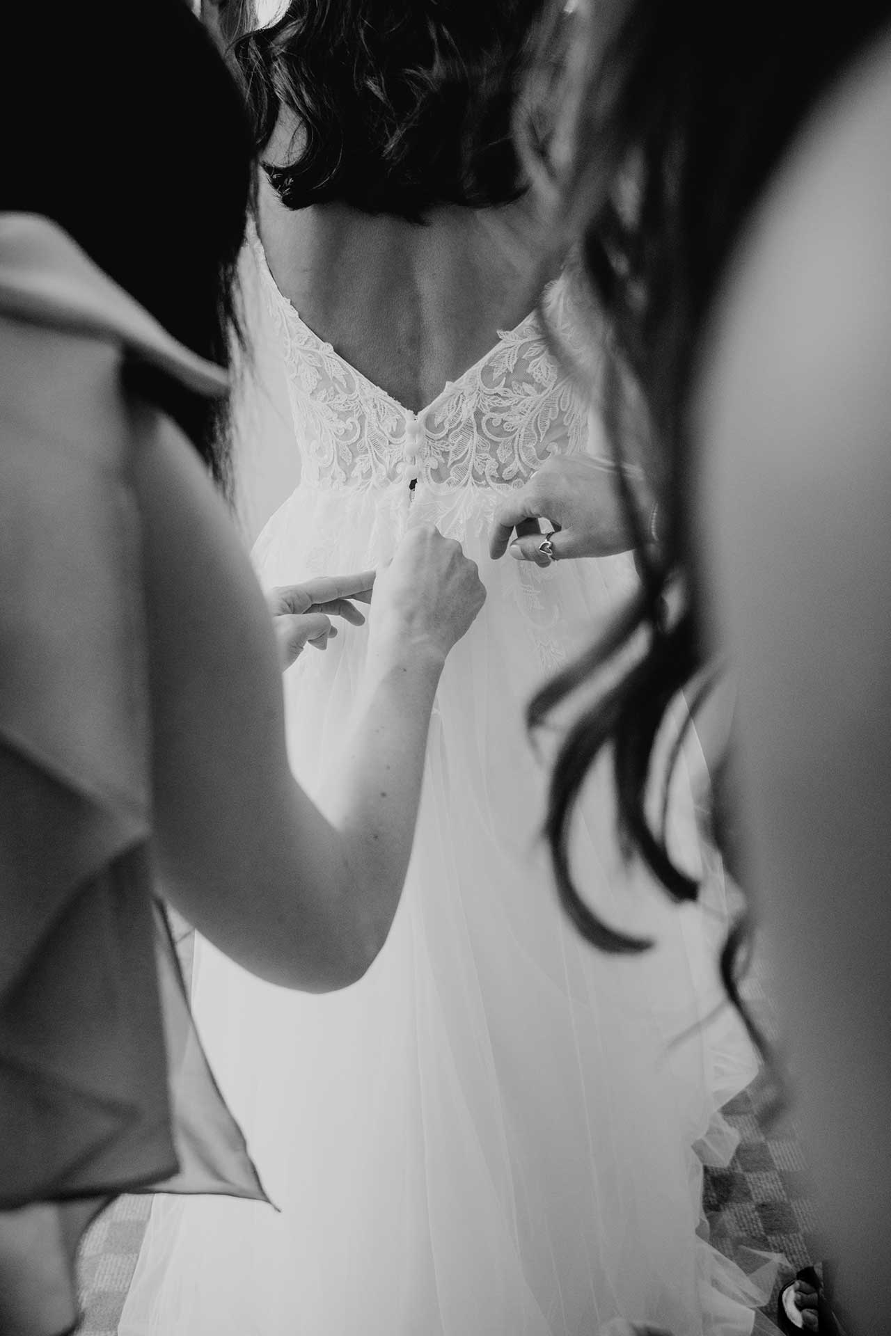 Braut wird ins Hochzeitskleid geholfen – Schloss Liebenberg