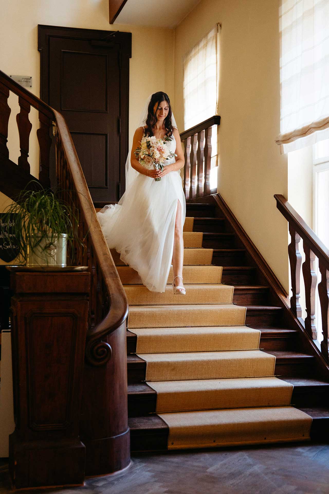 Braut schreitet die Treppe im Schloss und Gut Liebenberg hinunter – eleganter Moment der Schlosshochzeit, fotografiert von Laura-Sophie Jung