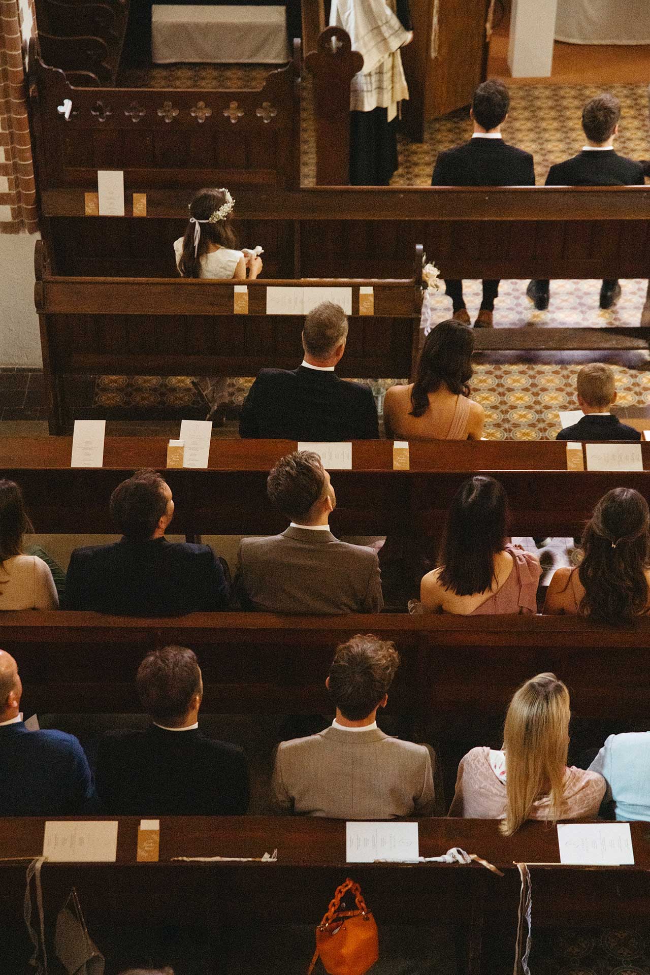 Gäste sitzen in den Kirchenbänken während der Hochzeitszeremonie im Schloss und Gut Liebenberg