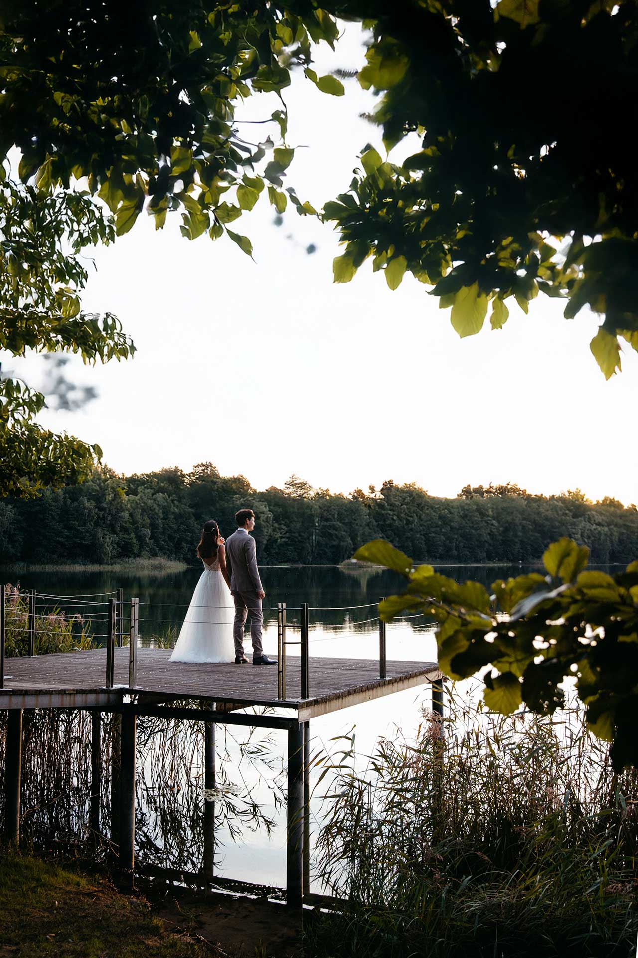 Hochzeitspaar bei Sonnenuntergang auf dem Steg am Seehaus Liebenberg – natürliche und zeitlose Hochzeitsfotos